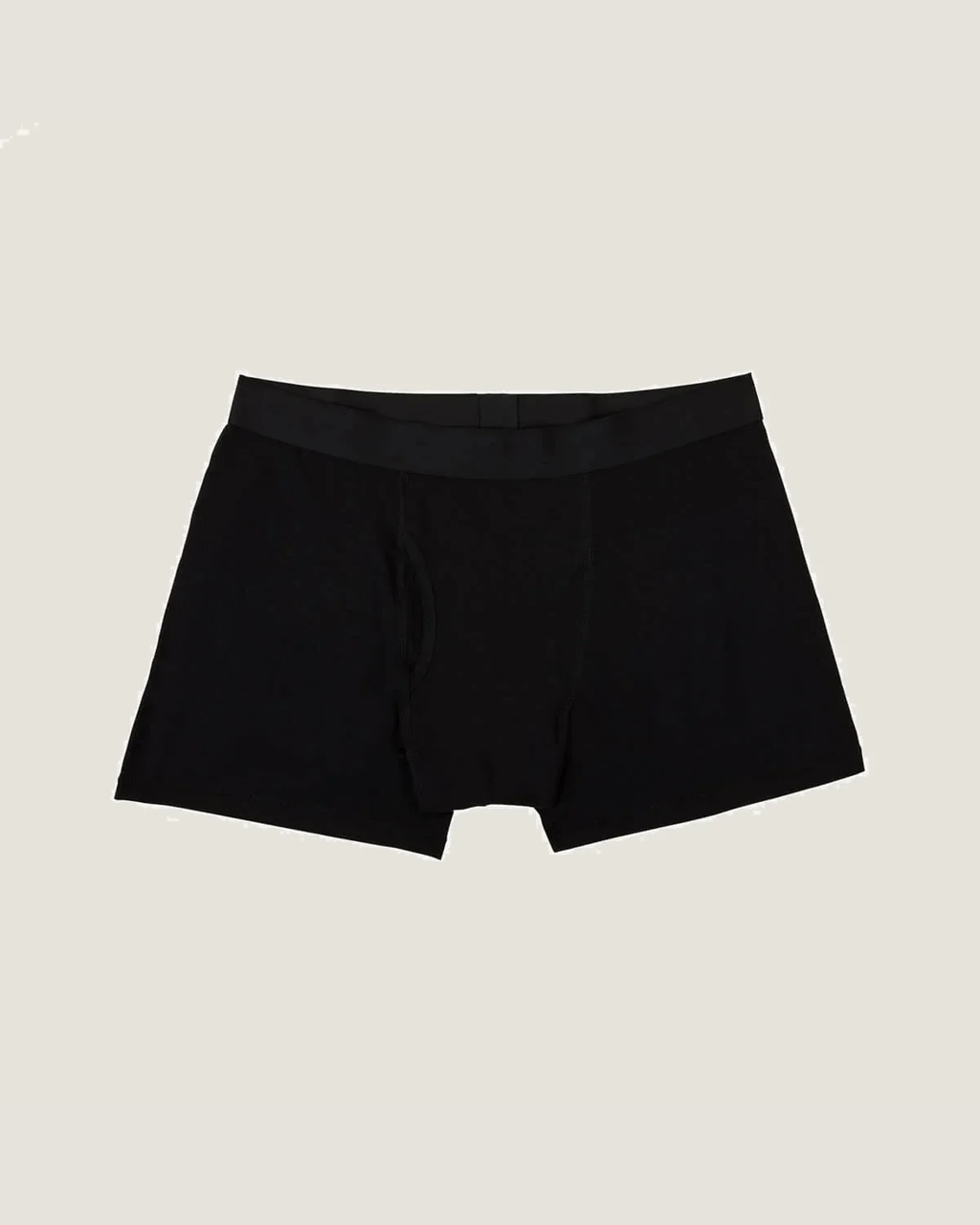 Black boxer briefs flat lay on off-white background