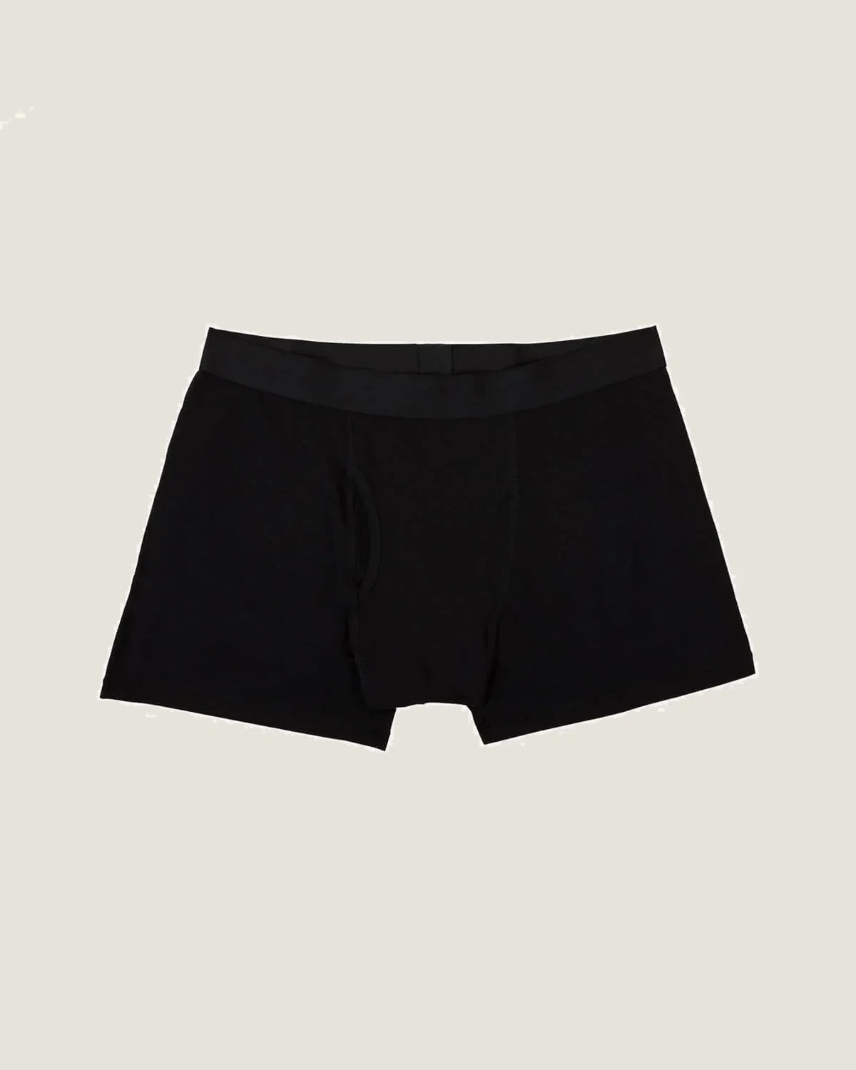 Black boxer briefs flat lay on off-white background