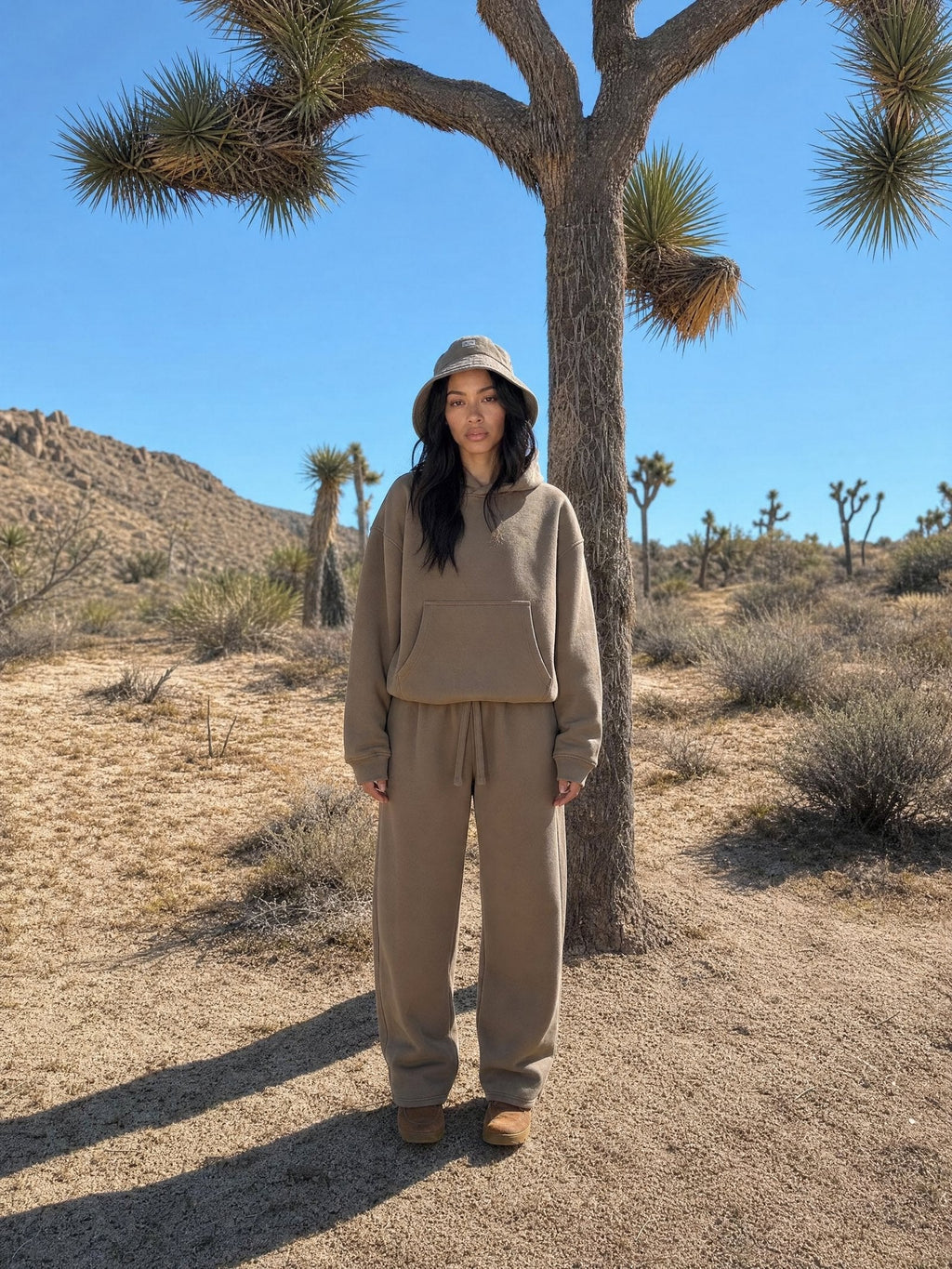 Warm tan hoodie and sweatpant set worn beside a Joshua tree